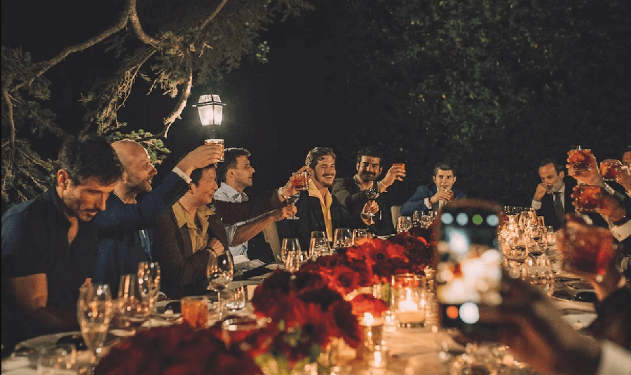 grupa mężczyzn pijąca negroni podczas wieczornego garden party - negroni jako męski drink dla faceta